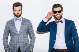 Two handsome men wearing Josh Bach bow ties. One is the apples and hats bow tie and the other is flying pigs bow tie. 